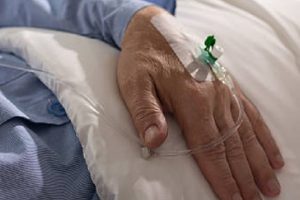 Close-up of terminally ill man's hand with drip
